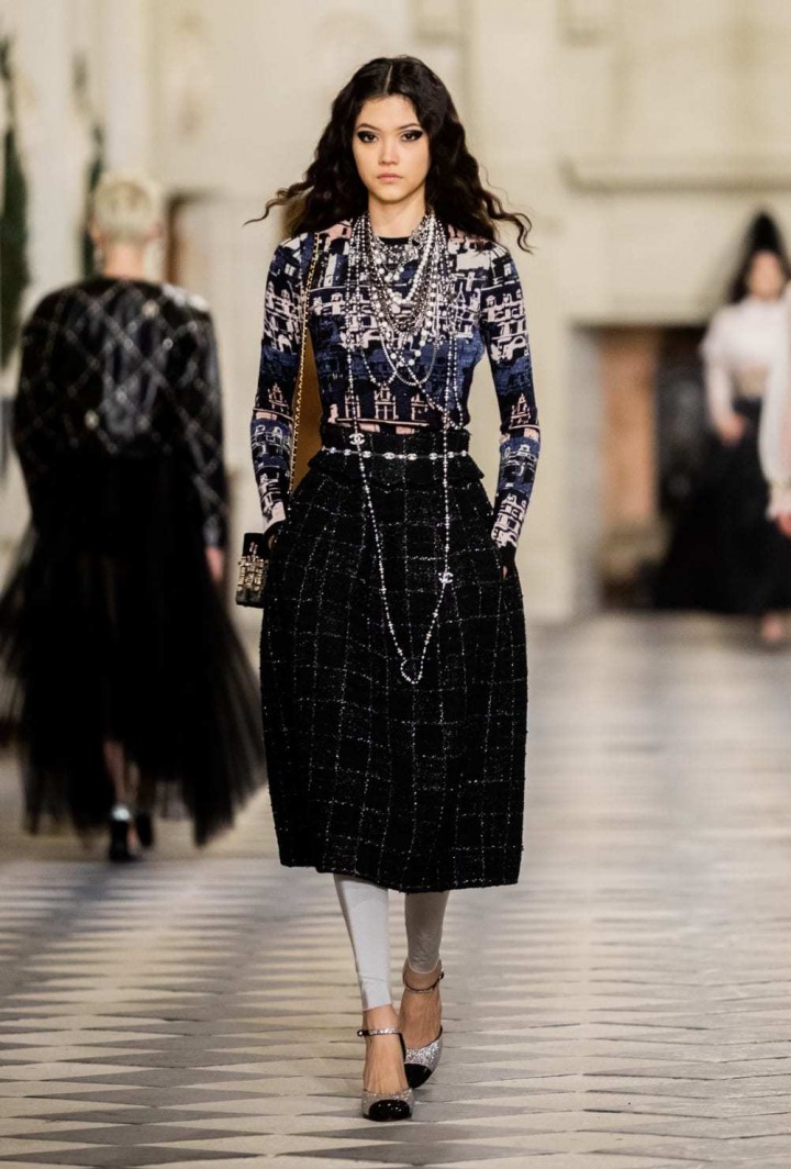 Žena v černém modelu Chanel Métiers d’art 2020/21