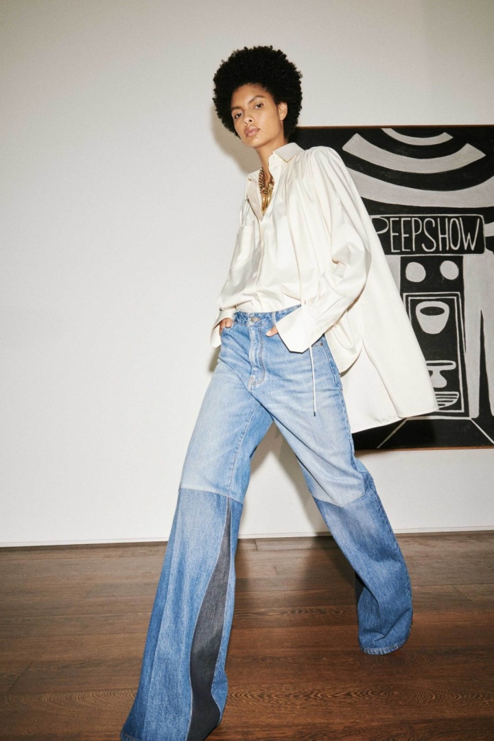Žena v džínách a bílém saku Victoria Beckham