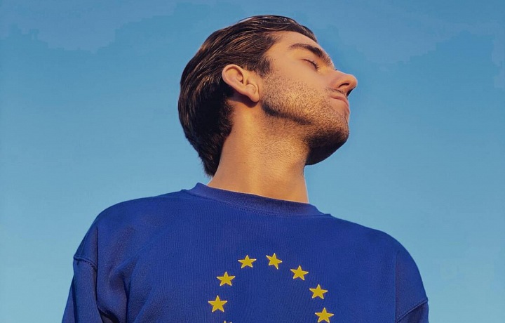 Muž se zavřenýma očima v mikině se symbolem EU.