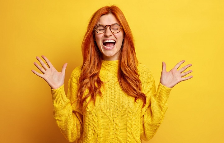 Žena se směje pod přívalem emocí